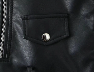 Close-up of black PU leather jacket featuring pebbled texture and silver metal zippers