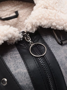 Detail of shearling collar and black leather trim with metal ring zipper on the jacket