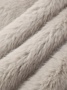 Macro shot of soft faux fur fabric with dense taupe long hair and elegant glossy texture