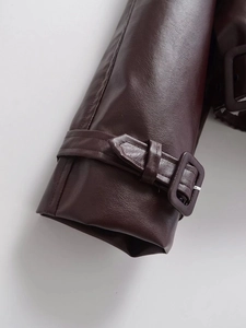 Détail du poignet d'une veste en cuir PU bordeaux avec sangle réglable et coutures nettes