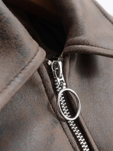 Detail of silver circular zipper pull on retro brown faux leather biker jacket