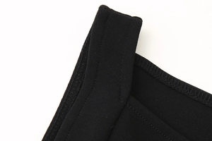 Detailansicht der Doppelnaht-Verstärkung und der feinen Stricktextur am schwarzen Kleid