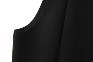 Detailansicht des schwarzen Strickkleides mit Overlock-Nähten und Armausschnitt-Finish