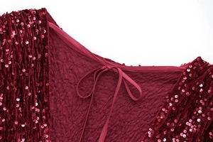 Detail of burgundy sequin mini dress featuring a bow tie neckline and padded shoulders