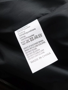 Detail view of the care label for women's PU biker jacket showing fabric composition