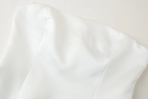 Close-up of the premium white satin fabric and precise stitching on the strapless top