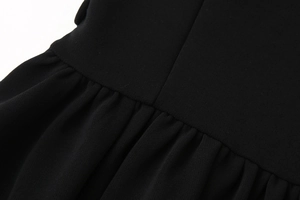 Detailansicht der Taillennähte und Falten des schwarzen ärmellosen Mini-Kleides