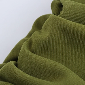 Macro shot of olive green pleated fabric texture on a long bodycon backless dress