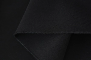 Detail-Makroaufnahme der hochwertigen schwarzen Strickstoffstruktur und feinen Nähte für Kleider