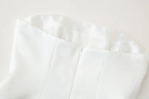 Detail view of the white top featuring a concealed back zipper and fine stitching