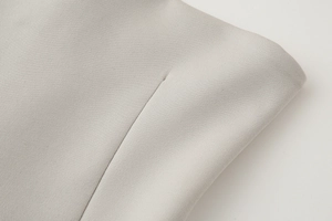 Macro shot of light gray pleated fabric texture and professional stitching details