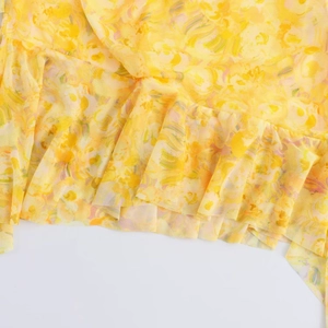 Close-up of yellow floral mesh fabric with ruffled layers and delicate textures