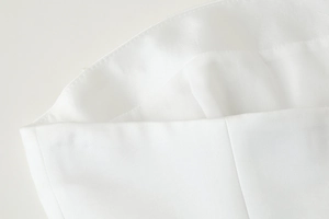 Detailed close-up showing white fabric texture and precise stitching of a Y2K tube top