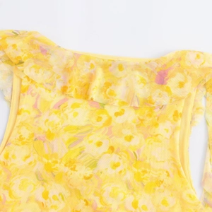 Close-up of the ruffled neckline on a yellow floral mesh sleeveless mini dress