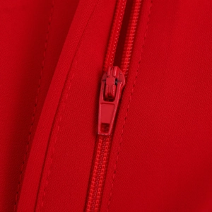Close-up of red knit fabric with high-density texture and matching color zipper detail