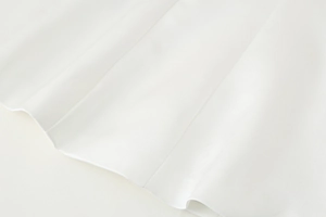 Detailed macro view of white Y2K satin fabric texture with vertical pleated stitching