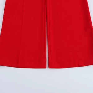 Detail view of red wide-leg trousers showing premium suit fabric drape and stitching