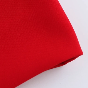 Macro view of bright red knit fabric texture and high-quality stitching on a garment