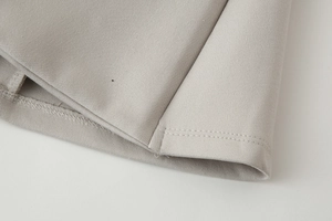 Close-up of double-stitched hem on the light gray woven y2k strapless bandeau top