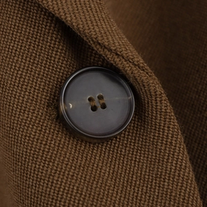 Macro detail of high-quality resin four-hole button and textured twill fabric on blazer