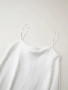 Débardeur minimaliste en soie blanche avec texture asymétrique et fines bretelles