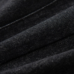 Detailed macro view of the premium black twill denim fabric texture and weaving