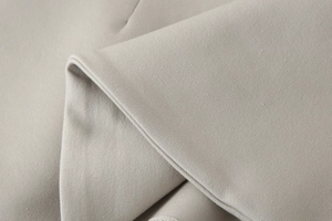 Close-up of premium light beige woven fabric texture showing fine structure and durability