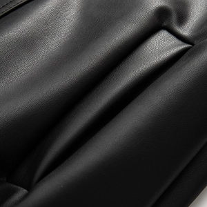 Detailed close-up showing the premium litchi texture on black PU leather jacket fabric