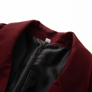 Dettaglio del risvolto del blazer bordeaux con fodera in raso e cuciture precise