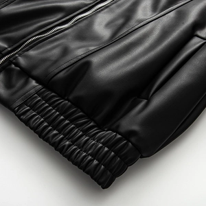 Detail of silver metal zipper and elastic hem on black PU leather cropped jacket