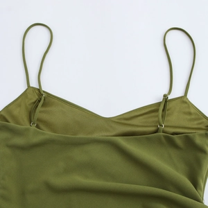 Close-up of army green backless maxi dress showing thin straps and silver metal buckles