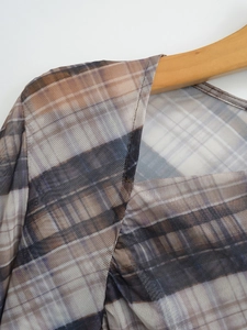 Close-up of semi-transparent mesh grid pattern and neck stitching on long sleeve top