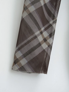 Détail du tissu en maille transparente avec motif à carreaux marron et bleu ciel