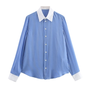 Détail du col pointu blanc contrasté et des poignets sur la chemise à rayures bleues
