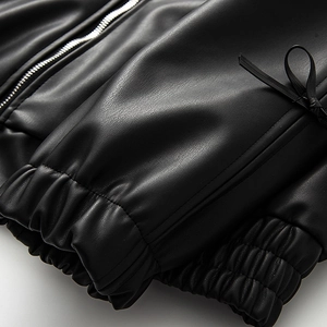 Detail of black PU leather jacket showing ribbed cuffs, side lace-up and silver metal zipper