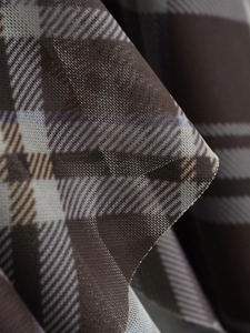 Vue macro des détails du tissu à carreaux marron avec texture sergée sur la robe