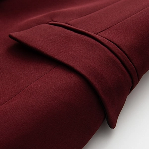 Dettaglio di un blazer rosso vino con cuciture precise e tessuto a trama di alta qualità