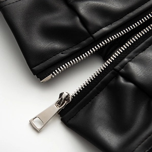 Macro shot of silver metal zipper and black pebble-grain PU leather texture on jacket