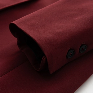 Dettaglio della manica di cappotto bordeaux con trama tessuta e due bottoni in resina