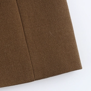 Macro shot of dark brown twill fabric texture and clean edge stitching detail
