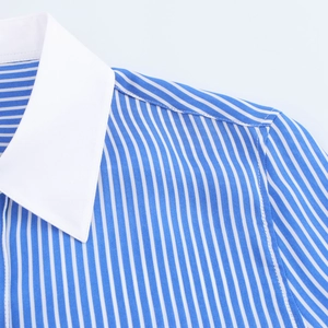 Détail d'une chemise à rayures bleues montrant le col blanc contrasté et la qualité de couture