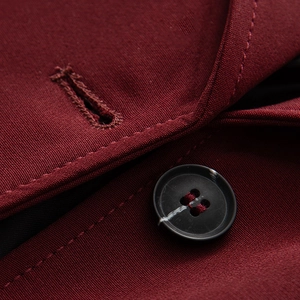 Macro del risvolto di un cappotto rosso scuro con bottone nero e trama in tessuto twill