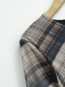 Détail du tissu en maille transparente avec motif à carreaux bruns sur cintre