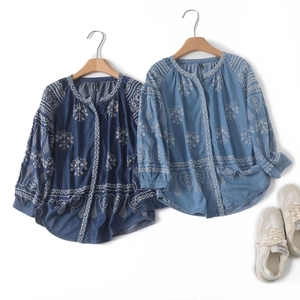Detailed view of floral embroidery on long-sleeved navy and blue bohemian cotton shirts