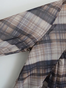 Close-up of the fine brown mesh stitching and grid pattern texture on the long sleeve top