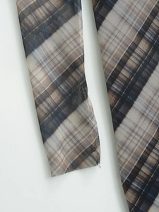 Vue macro d'un tissu en mesh translucide avec motif à carreaux marron et gris classique