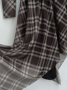 Gros plan sur un tissu mesh à carreaux marron et blanc avec une texture translucide