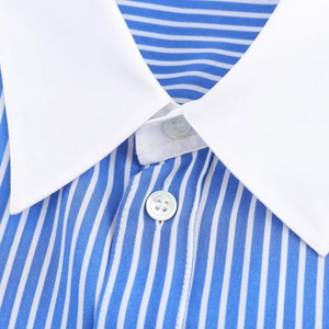 Détail du col blanc contrastant et du tissu à rayures bleues avec boutons en perles