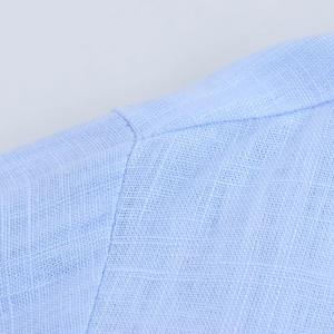 Gros plan sur la chemise en lin bleu clair avec texture et coutures d'épaule renforcées