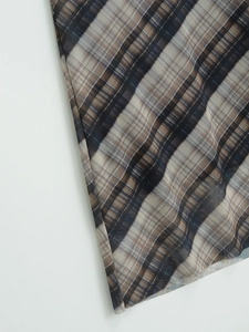 Vue macro détaillée du tissu en maille semi-transparent avec un motif à carreaux brun